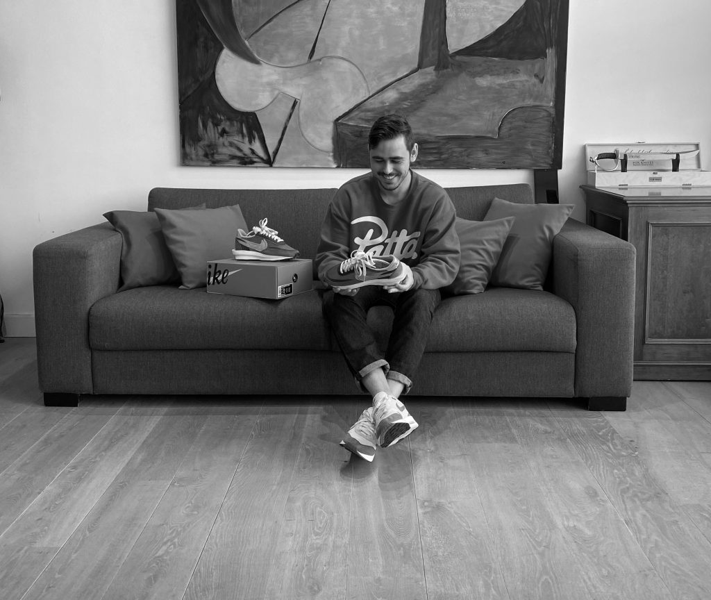 Arthur on the couch holding sneakers